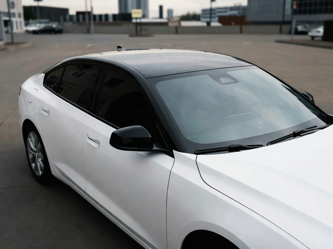 Contrasting gloss black roof wrap installed on a white sedan